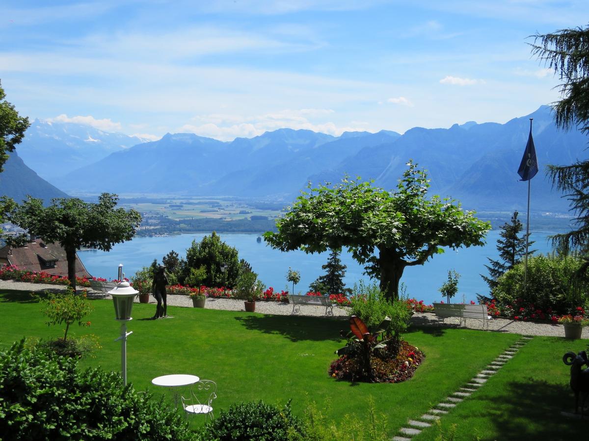 Landscaped Swiss hotel garden overlooking a lake and mountains